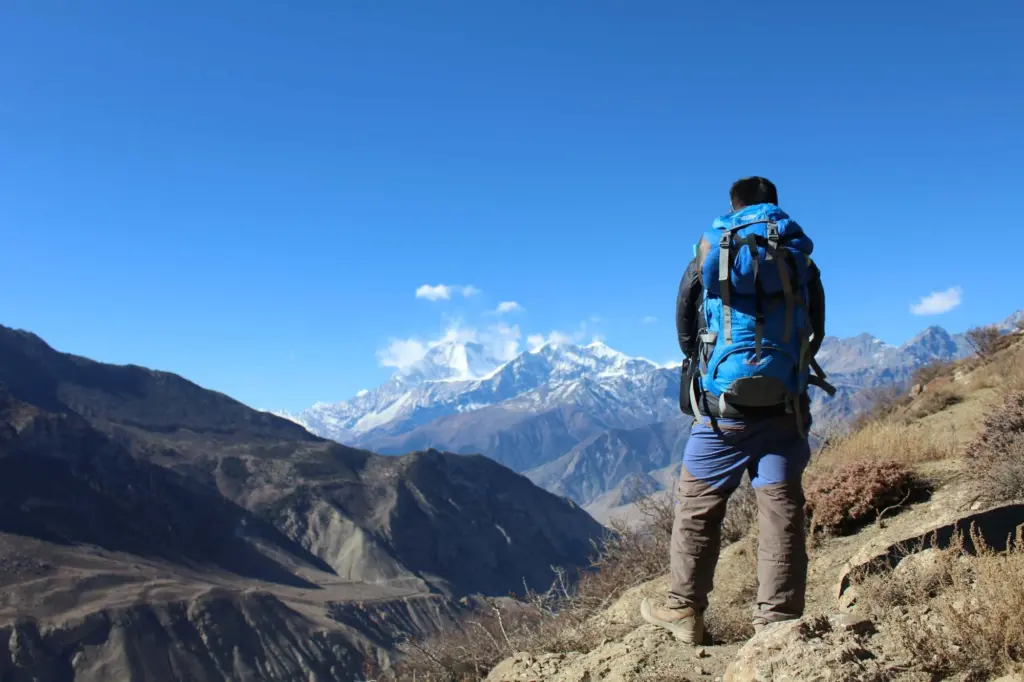 A man hiking in the mustang region with clear mountain views